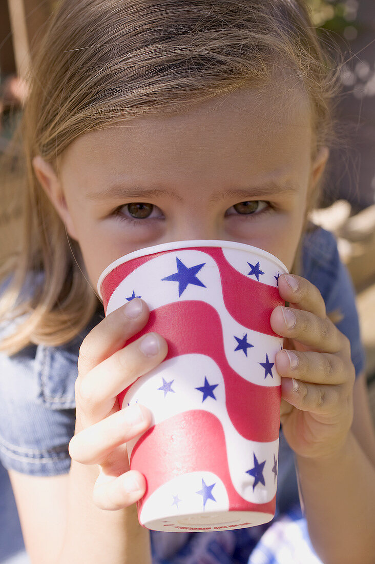 Kleines Mädchen trinkt aus Pappbecher (4th of July, USA)