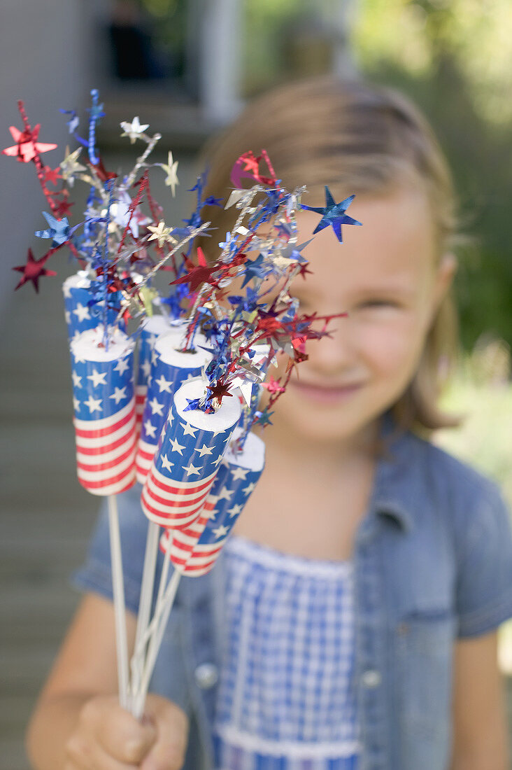 Kleines Mädchen hält Deko für den 4th of July (USA)