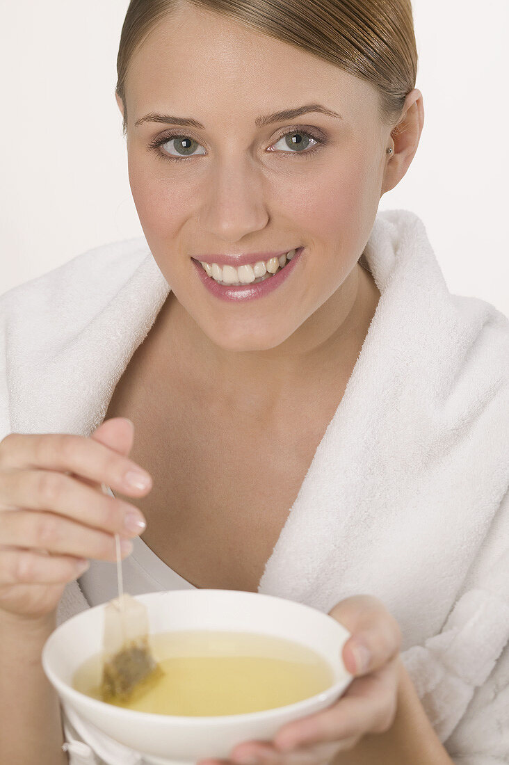 Woman with white towel and bowl of tea