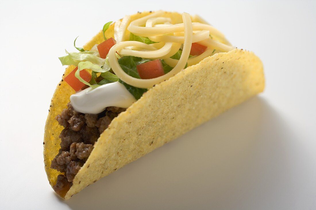 Taco filled with mince, lettuce, cheese and sour cream