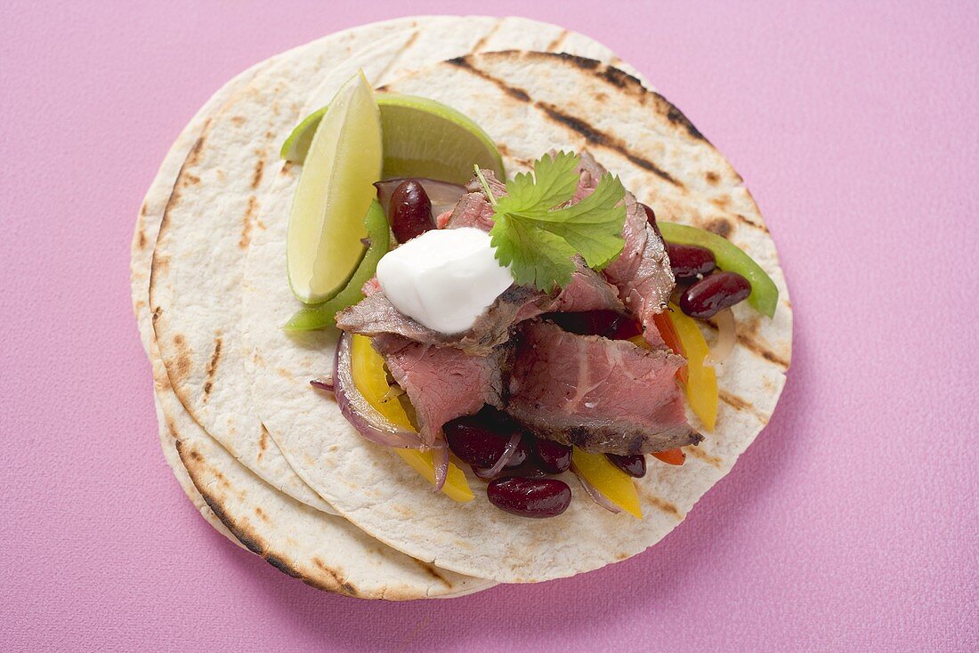 Beef fajita with beans, peppers and sour cream