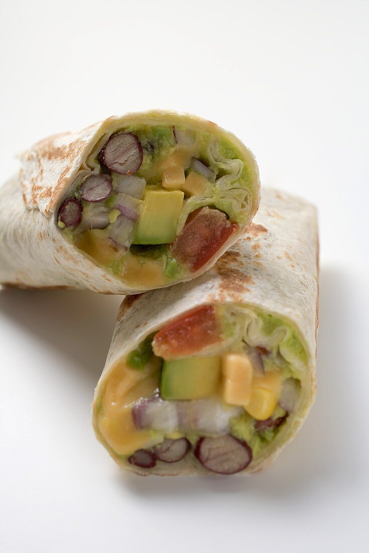 Two wraps filled with avocado, lettuce and cheese