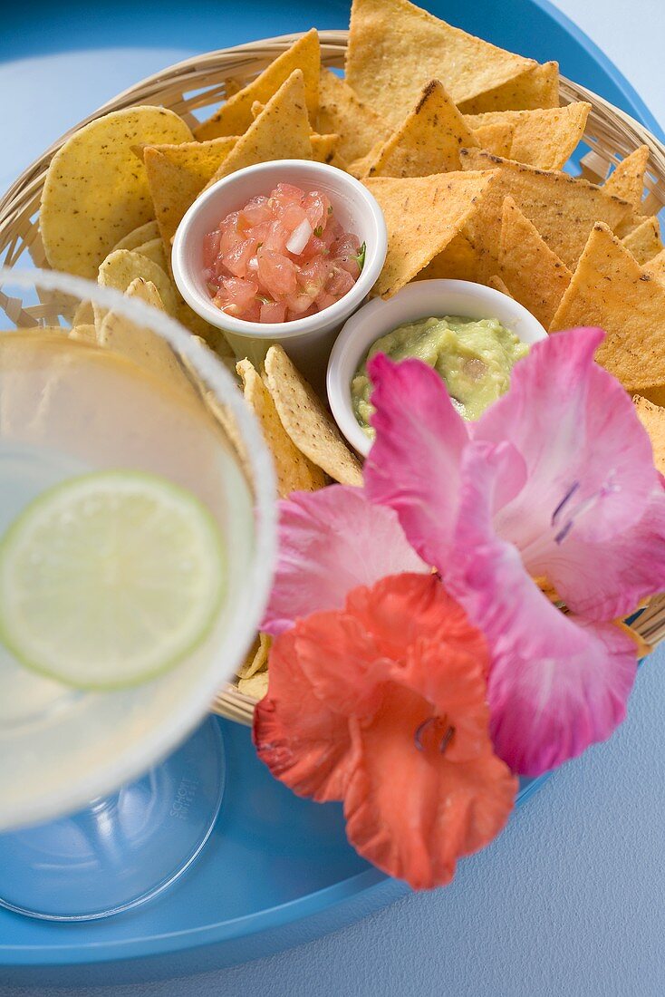 Nachos mit zwei Dips und Margarita auf Tablett