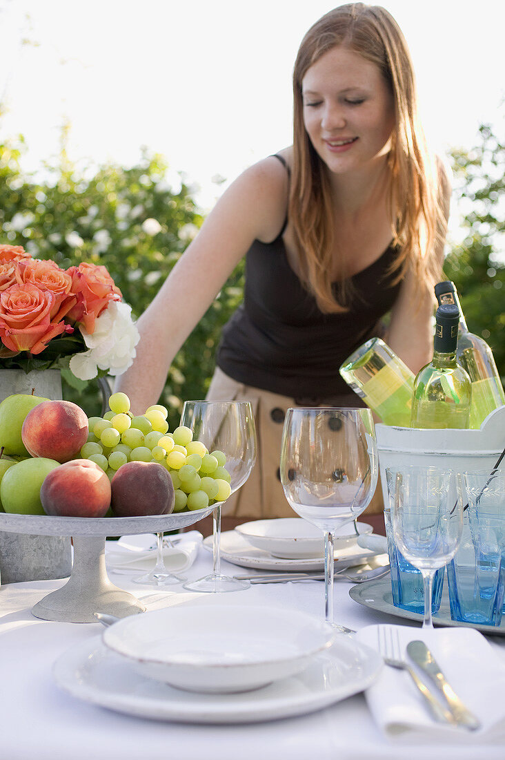 Frau beim gedeckten Tisch im Garten