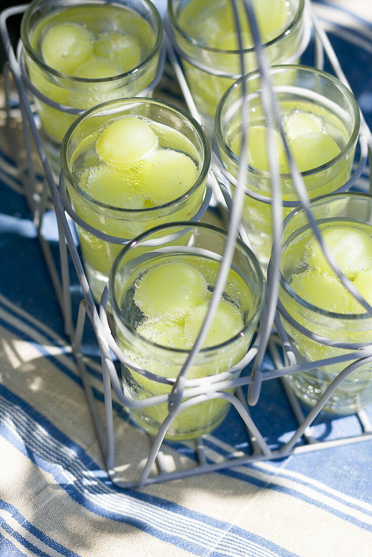 Wassergläser mit grünen Trauben im Träger