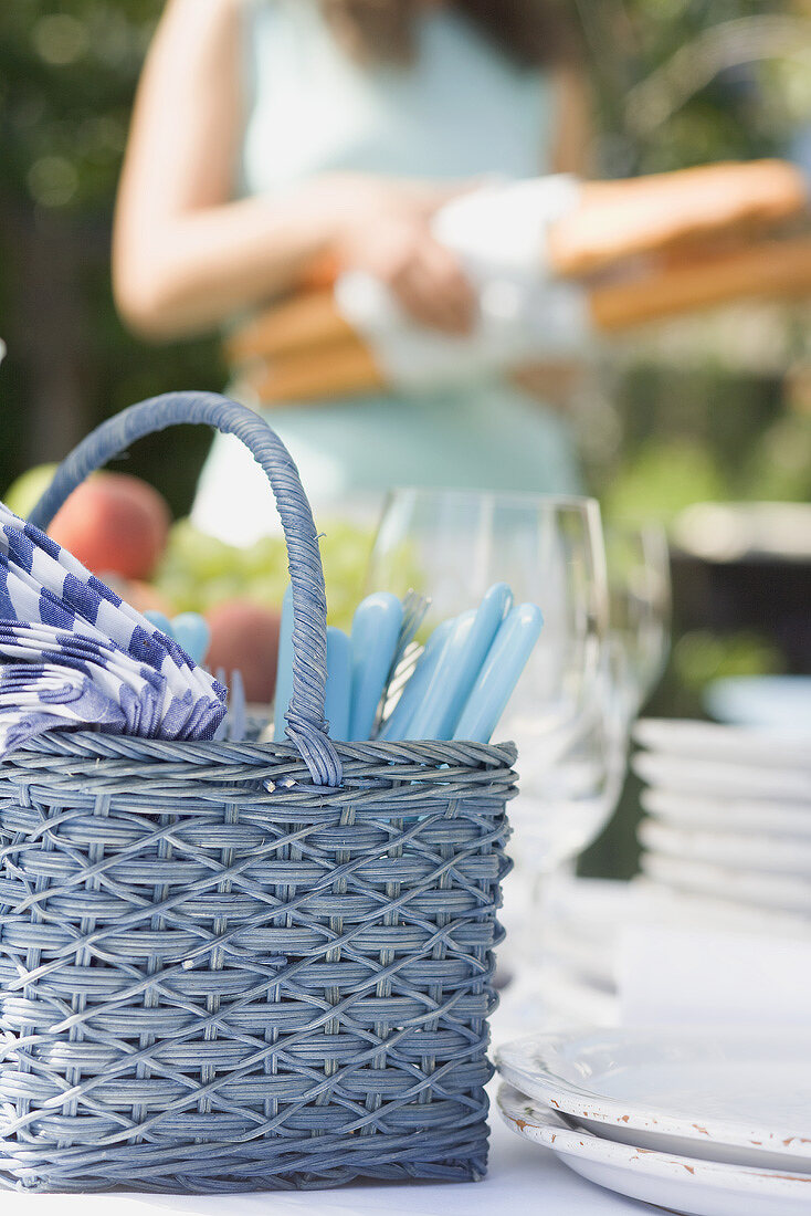 Gedeckter Tisch für ein Sommerfest, Frau im Hintergrund