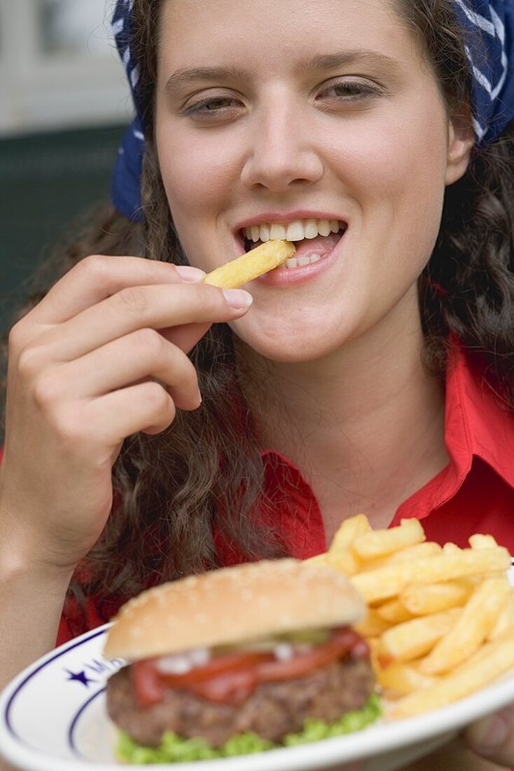 Frau isst Pommes frites