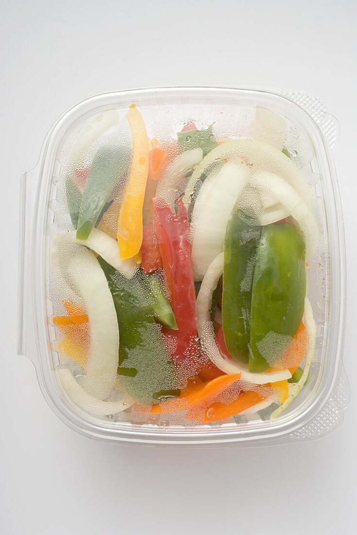 Sliced vegetables in plastic container (overhead view)
