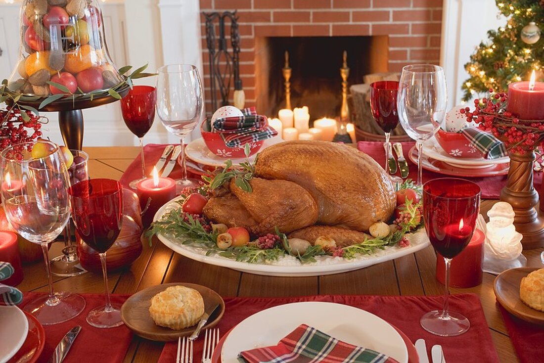 Christmas table with turkey in front of fireplace (USA)