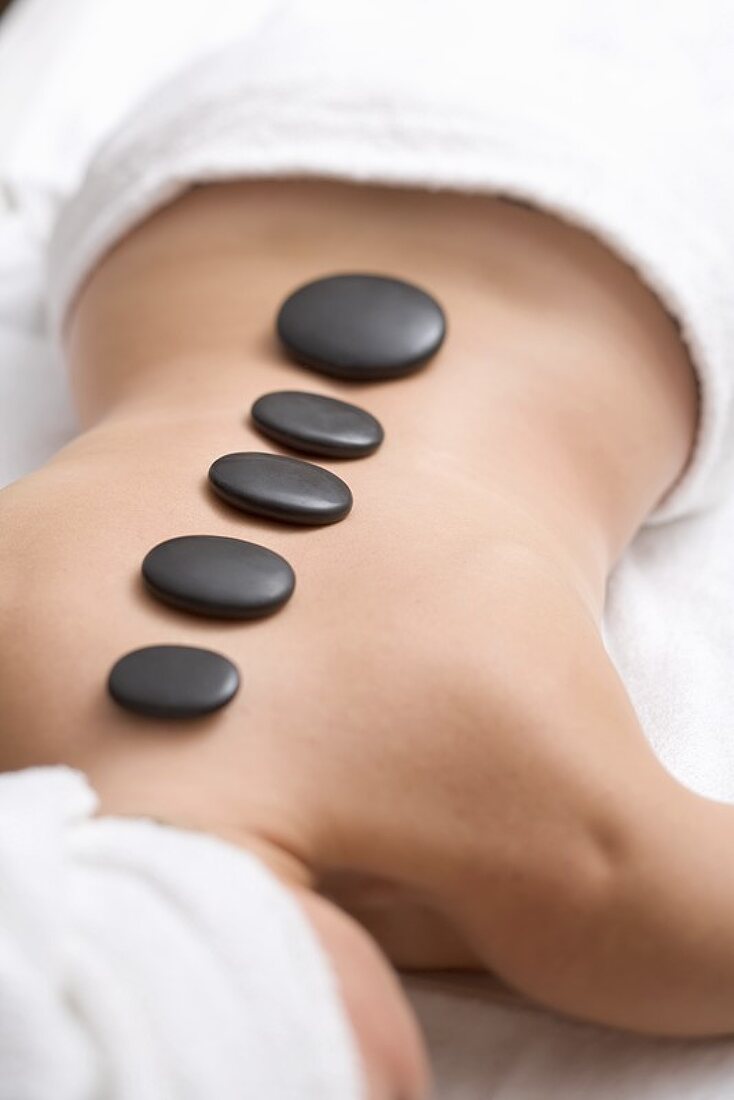 Woman having LaStone Therapy (healing therapy using stones)