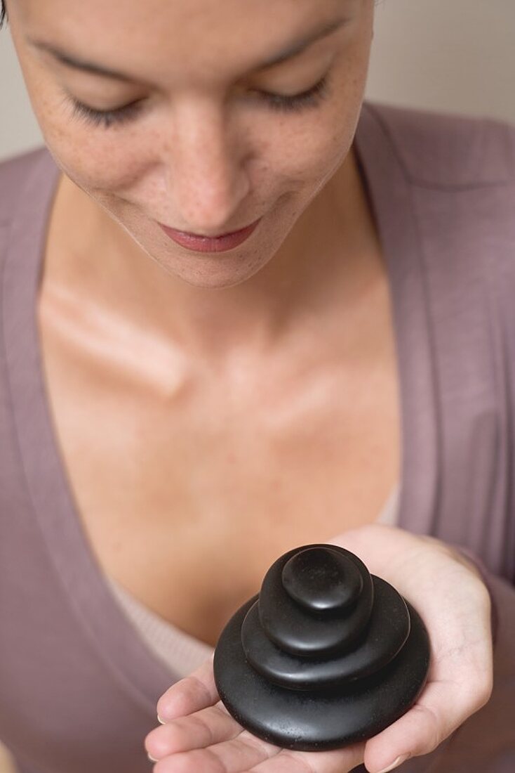 Woman holding stones for LaStone Therapy