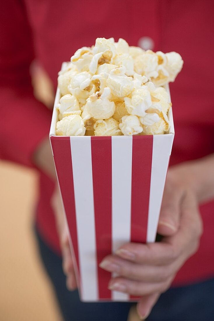 Frau hält Popcorn in gestreifter Tüte (4th of July, USA)