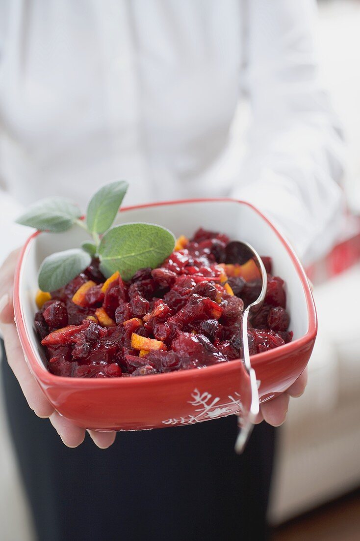 Frau hält Schale Cranberrysauce