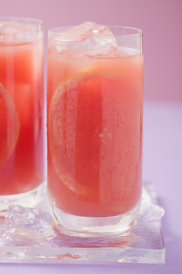 Zwei Gläser rosa Grapefruitsaft mit Eiswürfeln