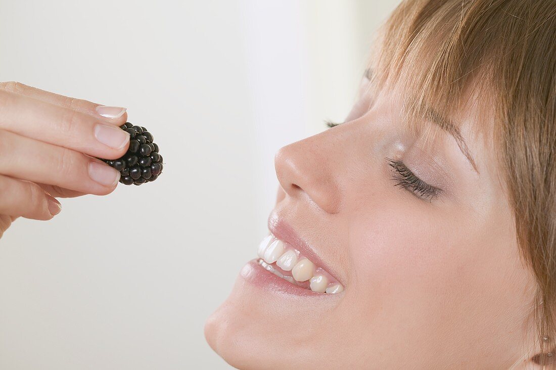 Woman holding a blackberry up to her mouth