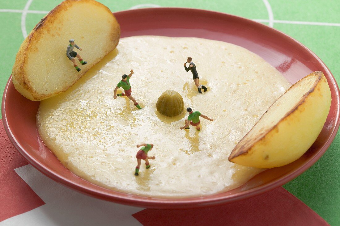 Raclette mit Kartoffeln, Gewürzgurke und Minifussballspielern