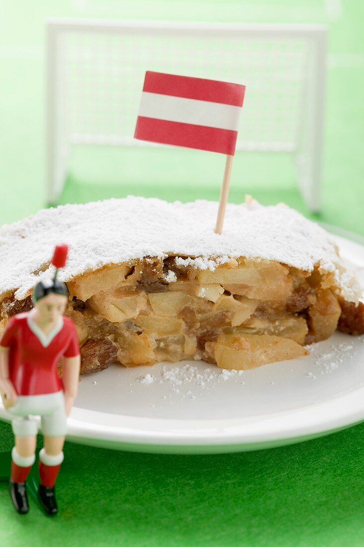 Stück Apfelstrudel mit österreichischer Flagge auf Teller