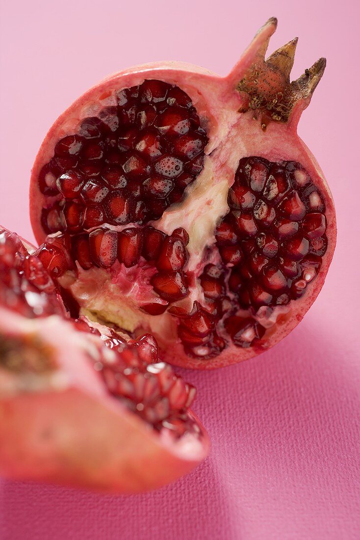 Pomegranate, halved, on pink background