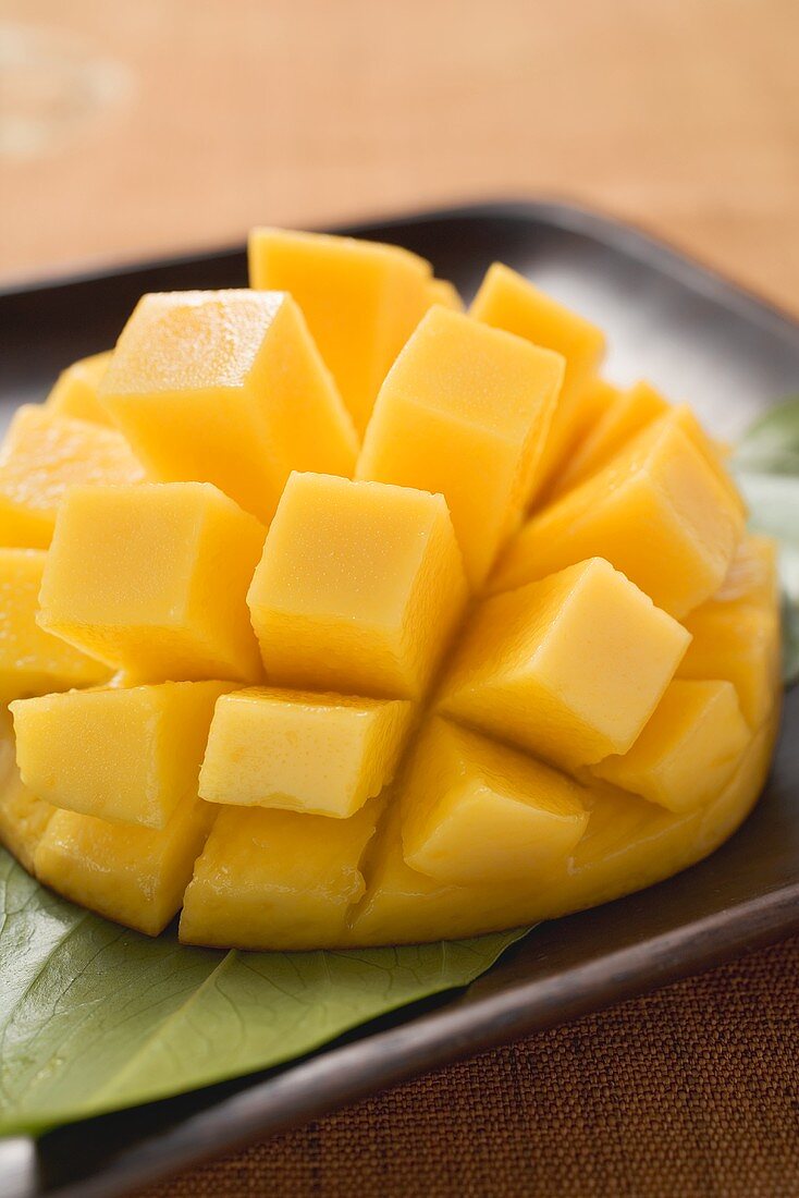 Aufgeschnittene Mango auf braunem Teller