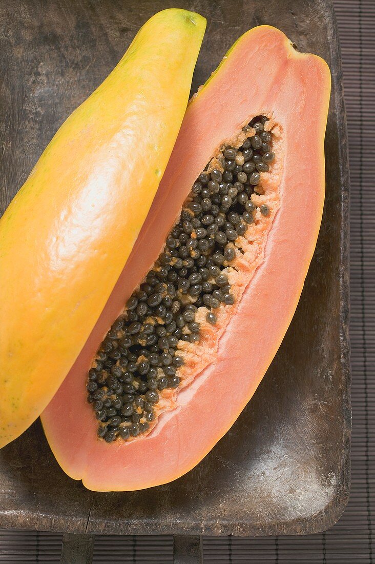 Papaya, halved, in wooden bowl