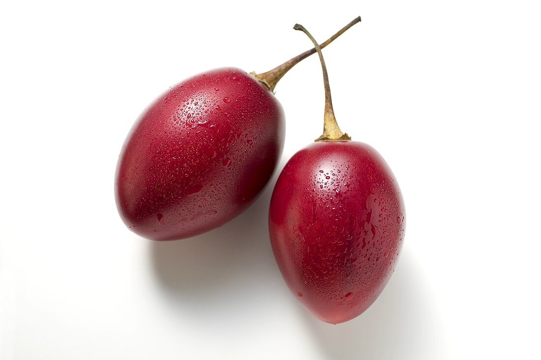 Two tamarillos with drops of water