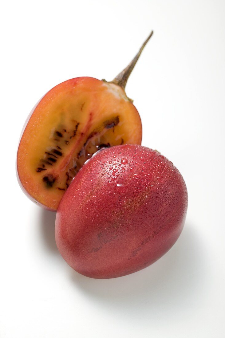 Tamarillo with drops of water, halved