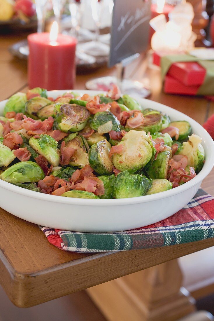 Rosenkohl mit Speck auf weihnachtlich gedecktem Tisch (USA)