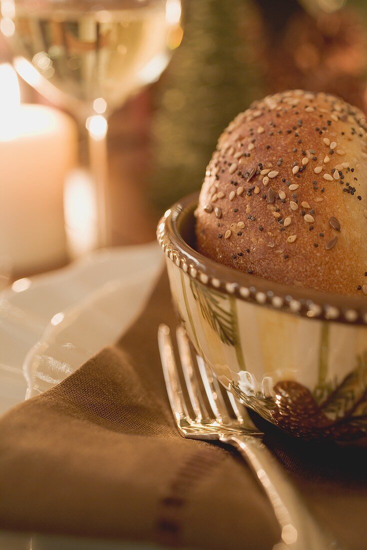 Gedeck mit Sesambrötchen auf weihnachtlichem Tisch (Close Up)