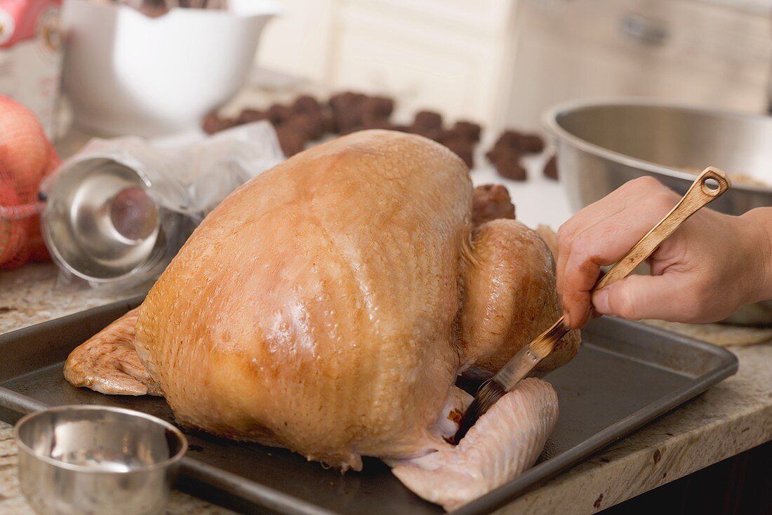 Brushing turkey with marinade