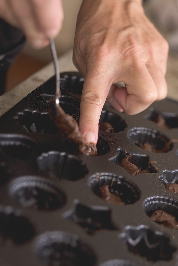 Making chocolate petit fours (Putting mixture into baking tin)