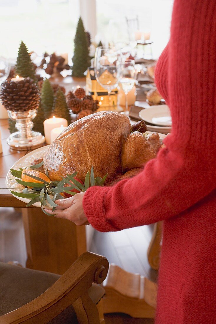 Woman serving roast turkey (Christmas)