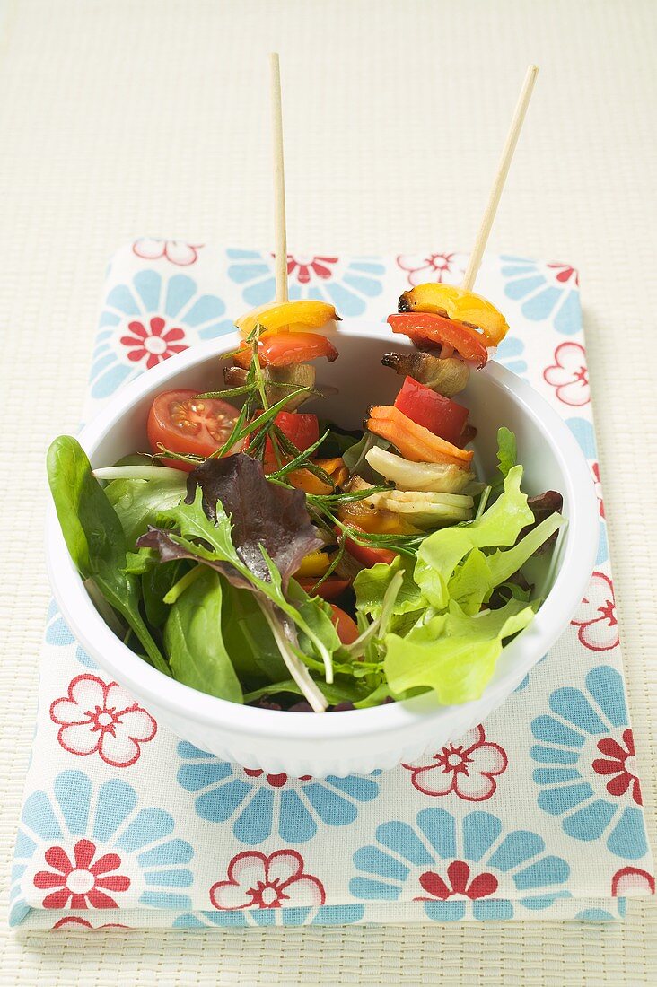 Salad leaves with mixed vegetable skewers