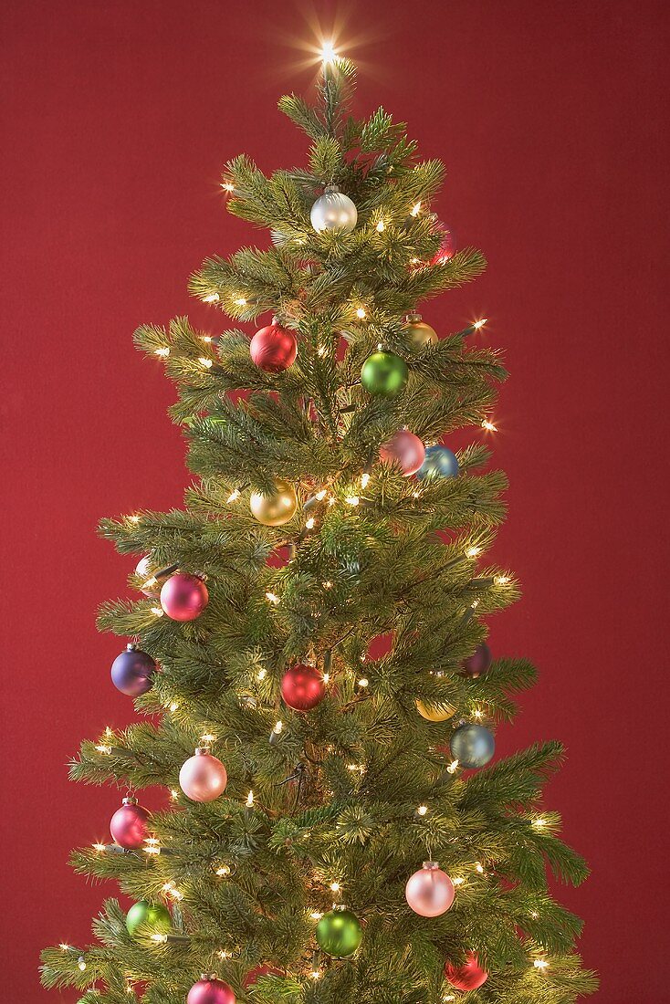 Christmas tree with coloured baubles and fairy lights