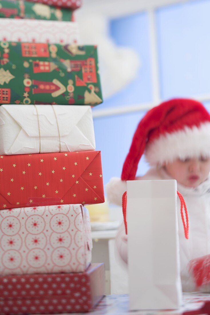 Verschiedene Weihnachtsgeschenke, Kind mit Weihnachtsmütze
