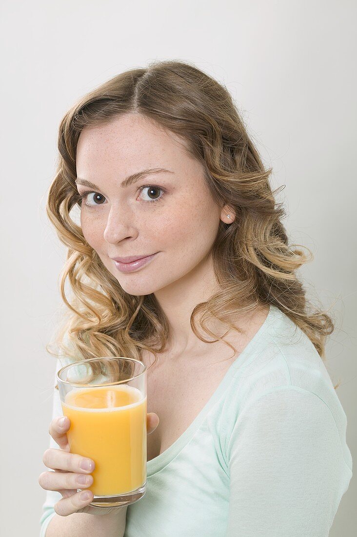 Woman holding glass of orange juice