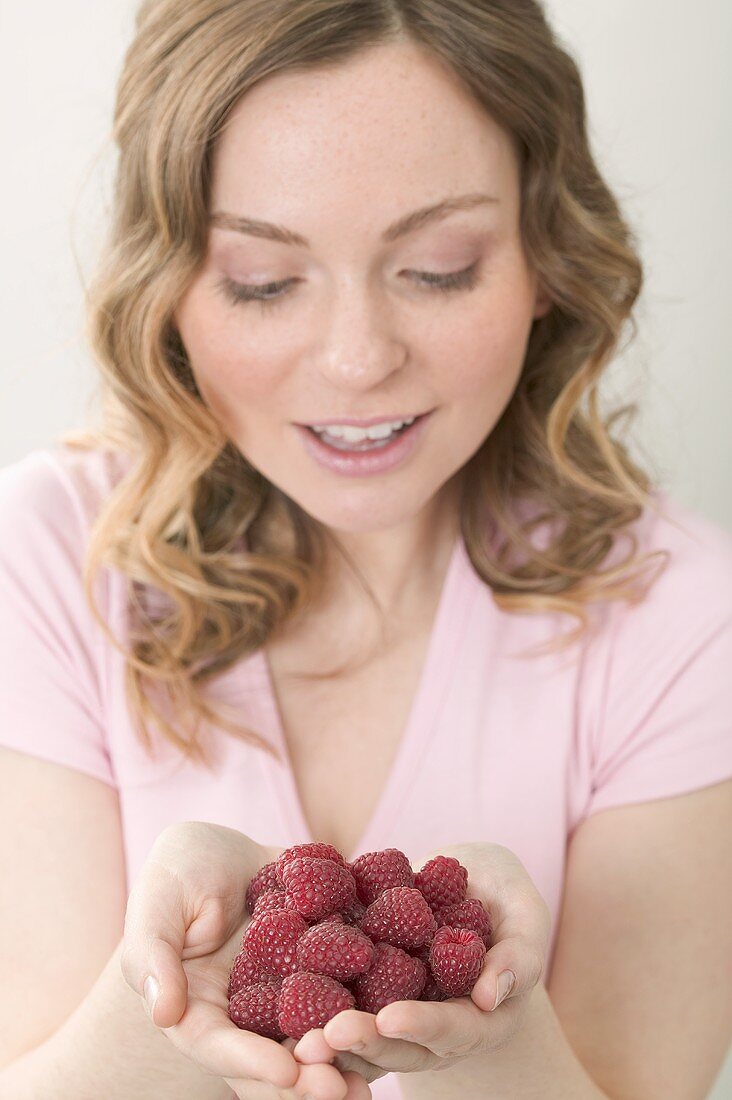 Woman holding fresh raspberries