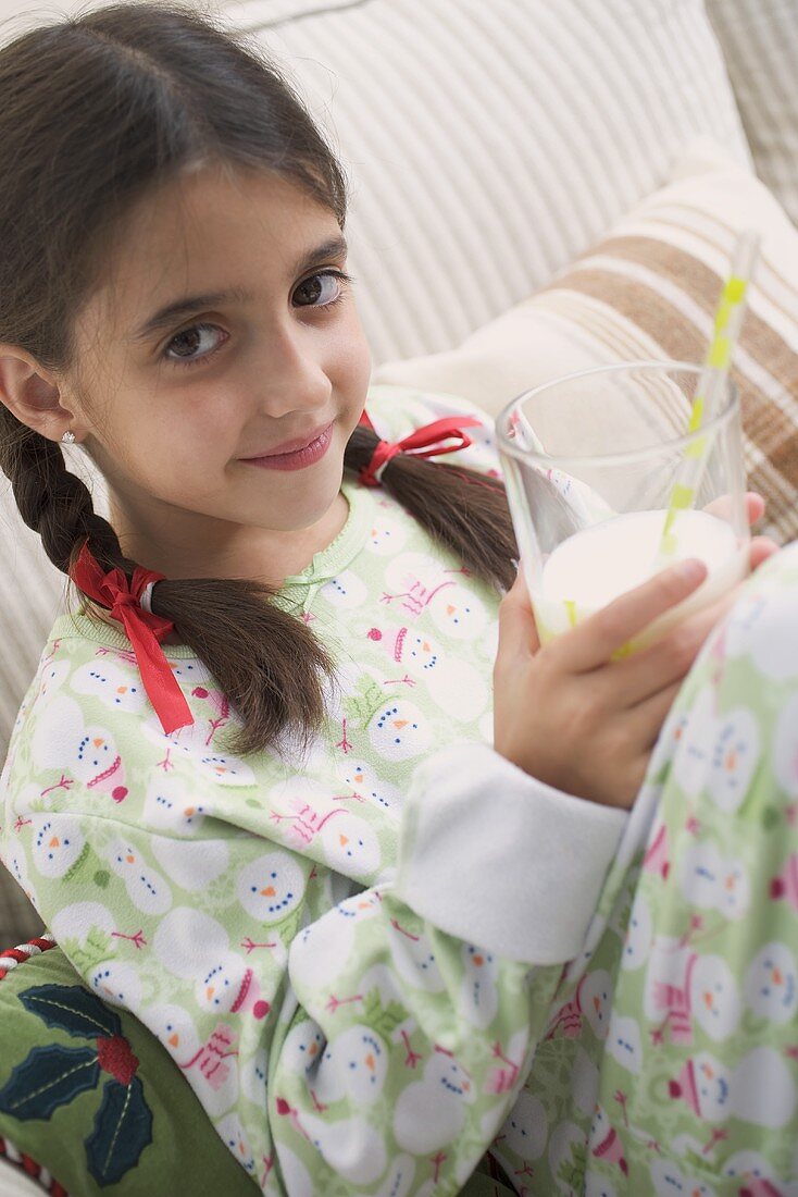 Mädchen hält Glas Milch mit Strohhalm