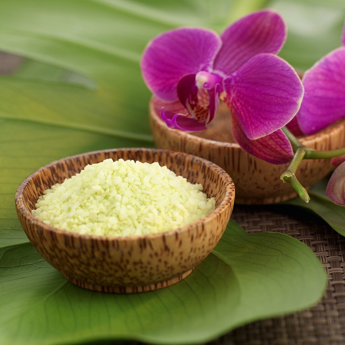 Bath salts and purple orchid in wooden bowls