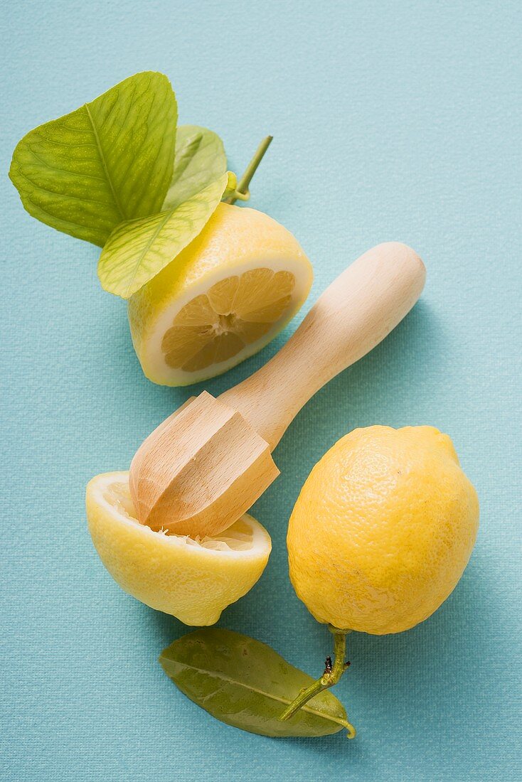 Lemons, whole, halved and squeezed, with citrus squeezer