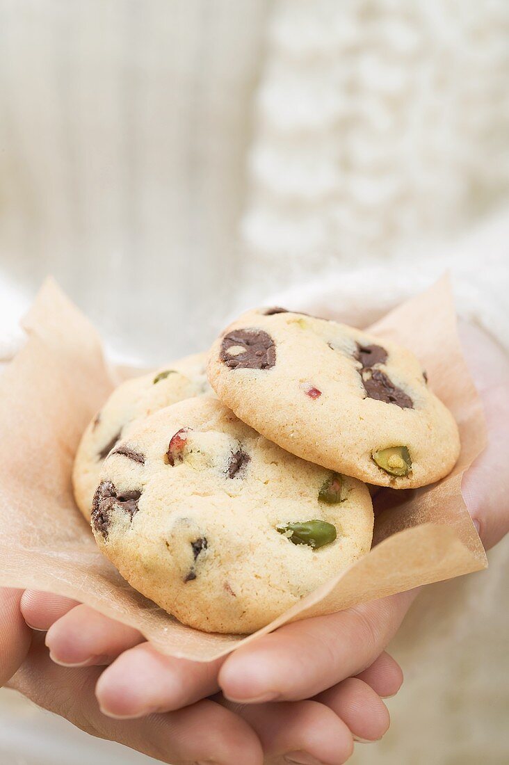 Hände halten Chocolate Chip Cookies mit Cranberries