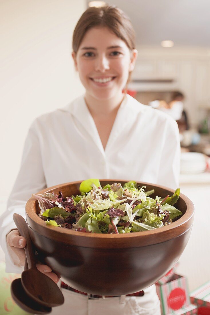 Junge Frau hält grosse Salatschüssel