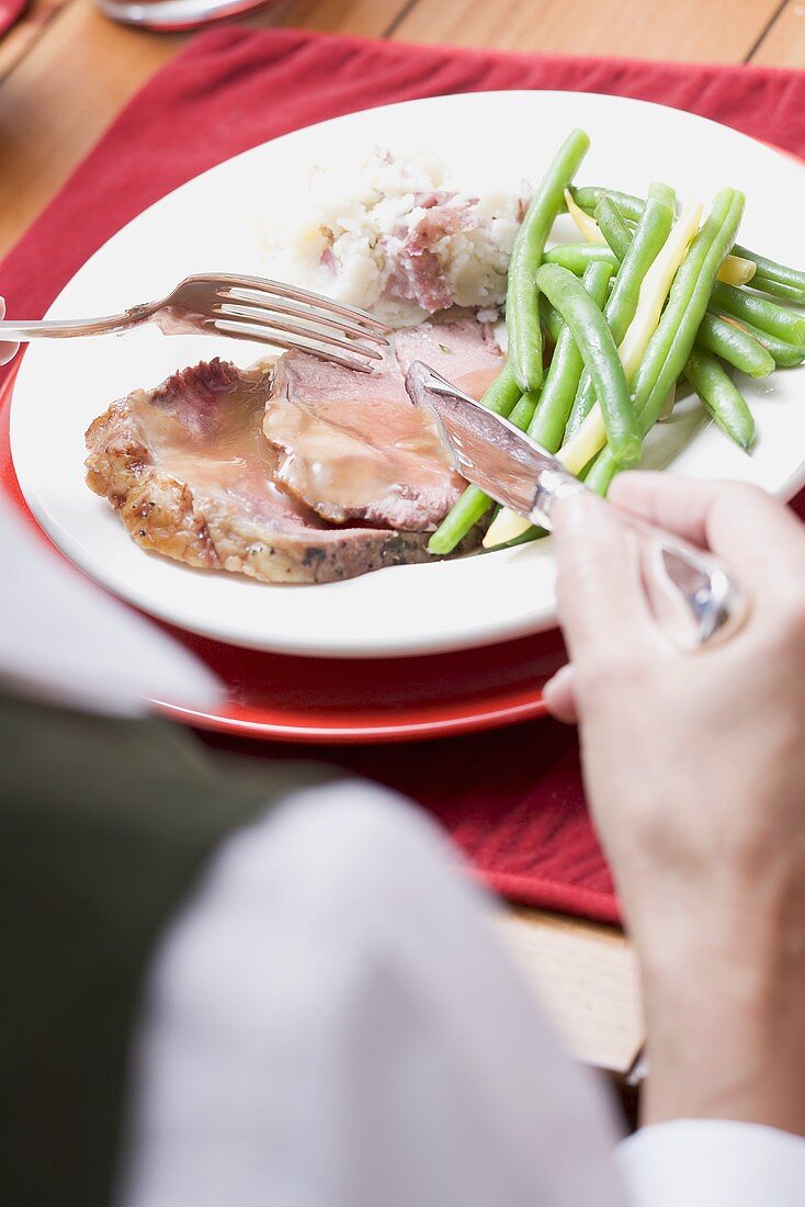 Woman eating roast turkey with green beans (Christmas)