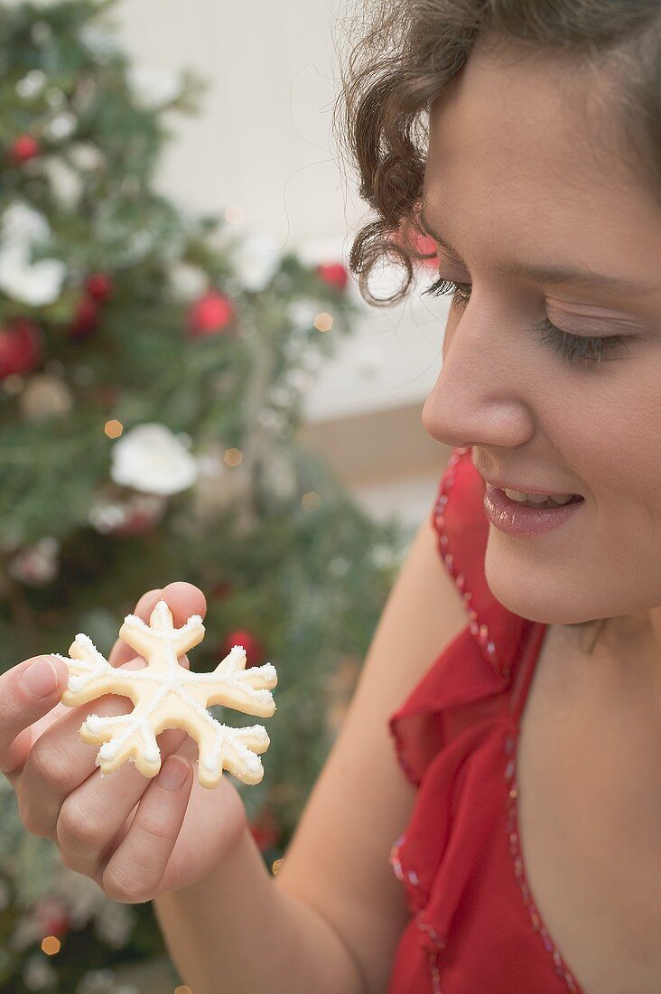 Frau hält Weihnachtsplätzchen