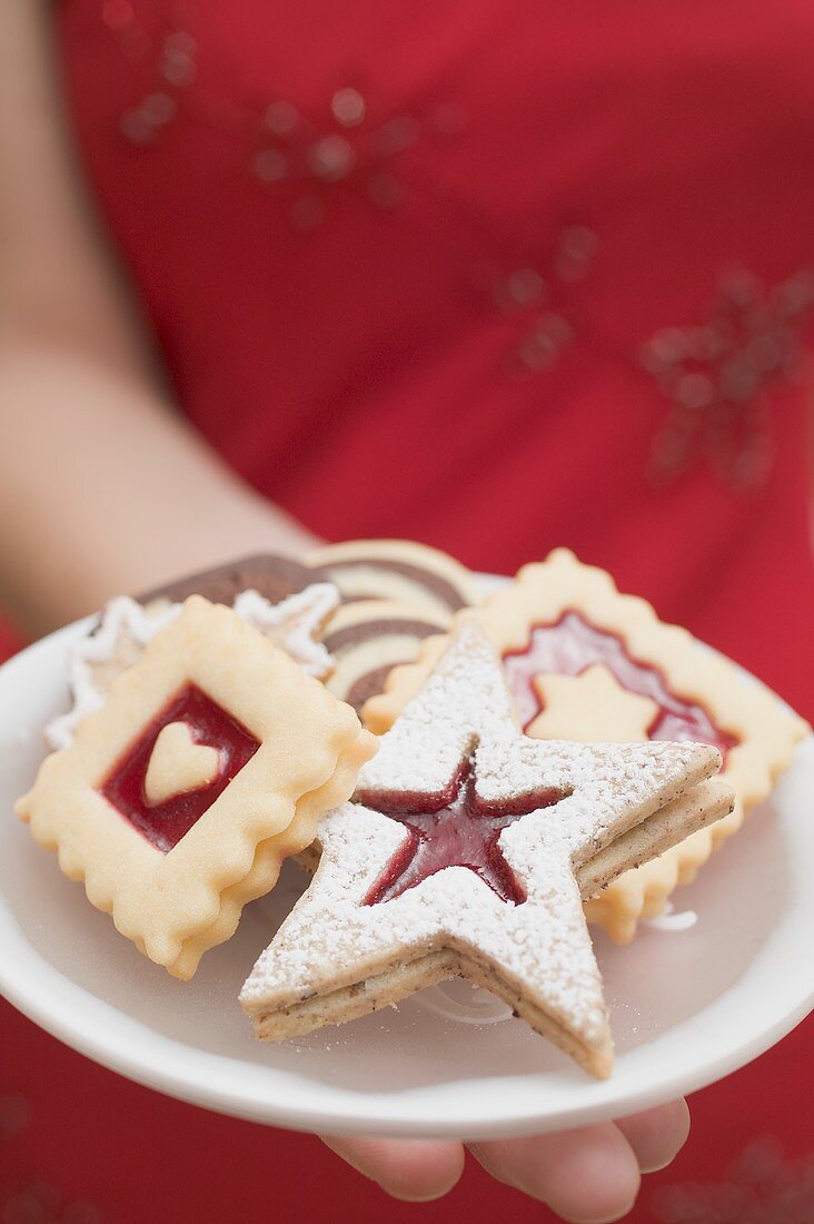 Frau hält verschiedene Weihnachtsplätzchen