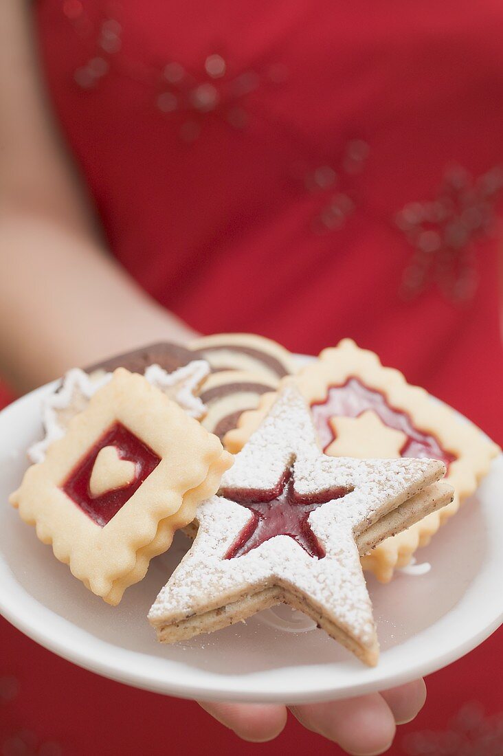Woman holding assorted Christmas biscuits