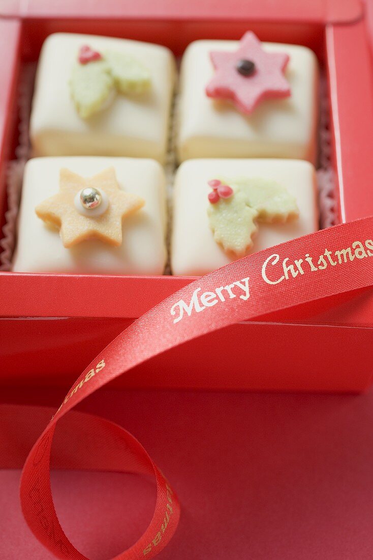 Vier weihnachtliche Petit Fours in roter Schachtel