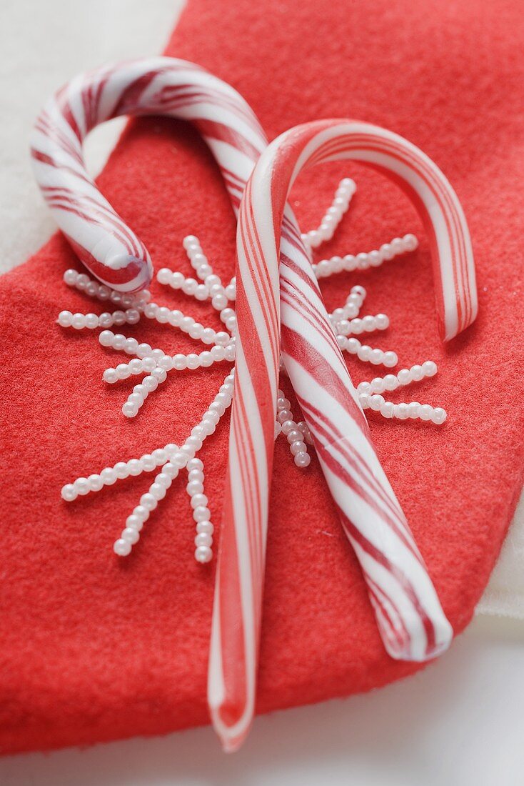 Zwei Zuckerstangen auf rotem Filzstiefel