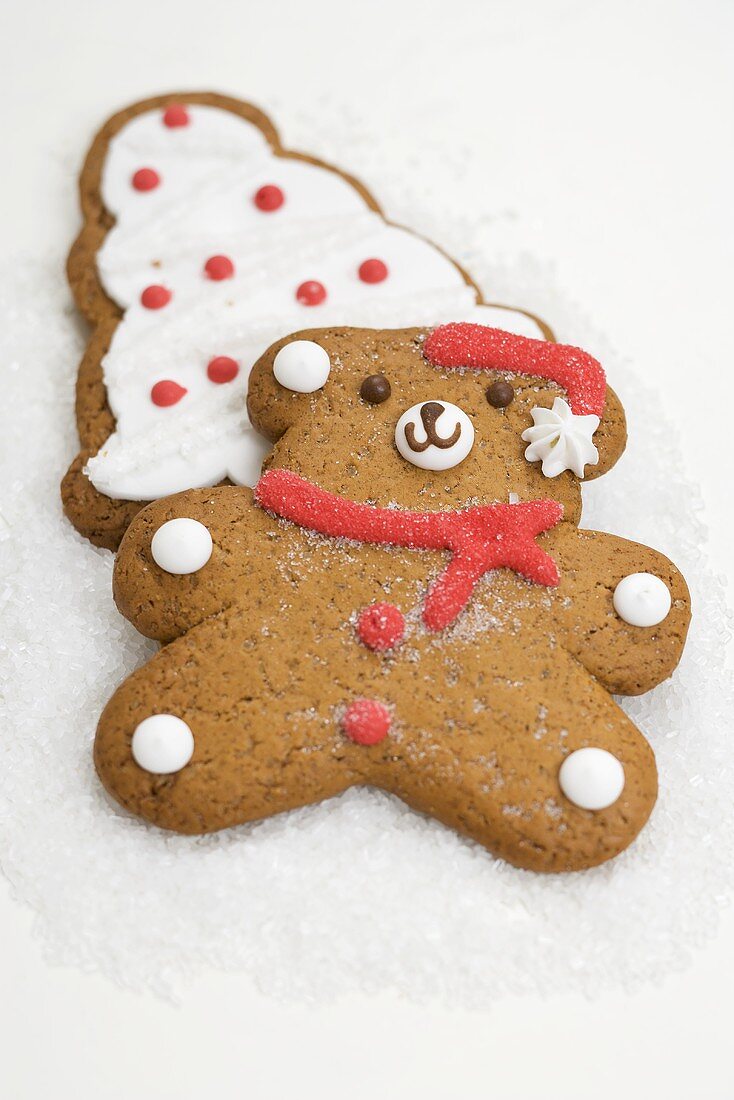 Two Christmas biscuits (teddy bear & Christmas tree) on sugar