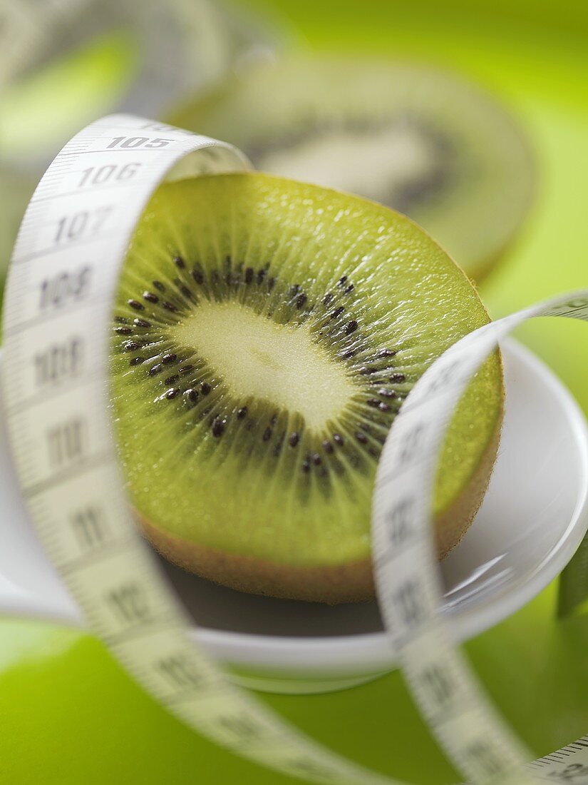 Half a kiwi fruit with tape measure