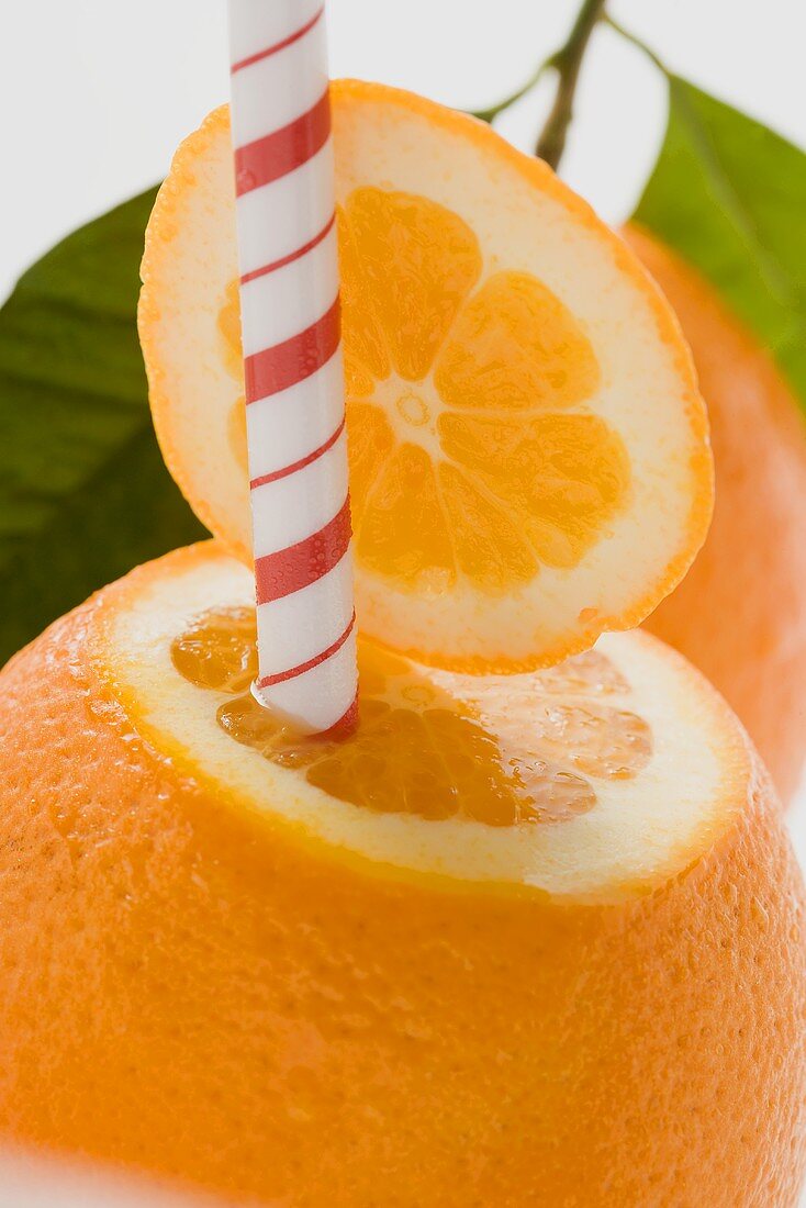 Orange with straw (close-up)